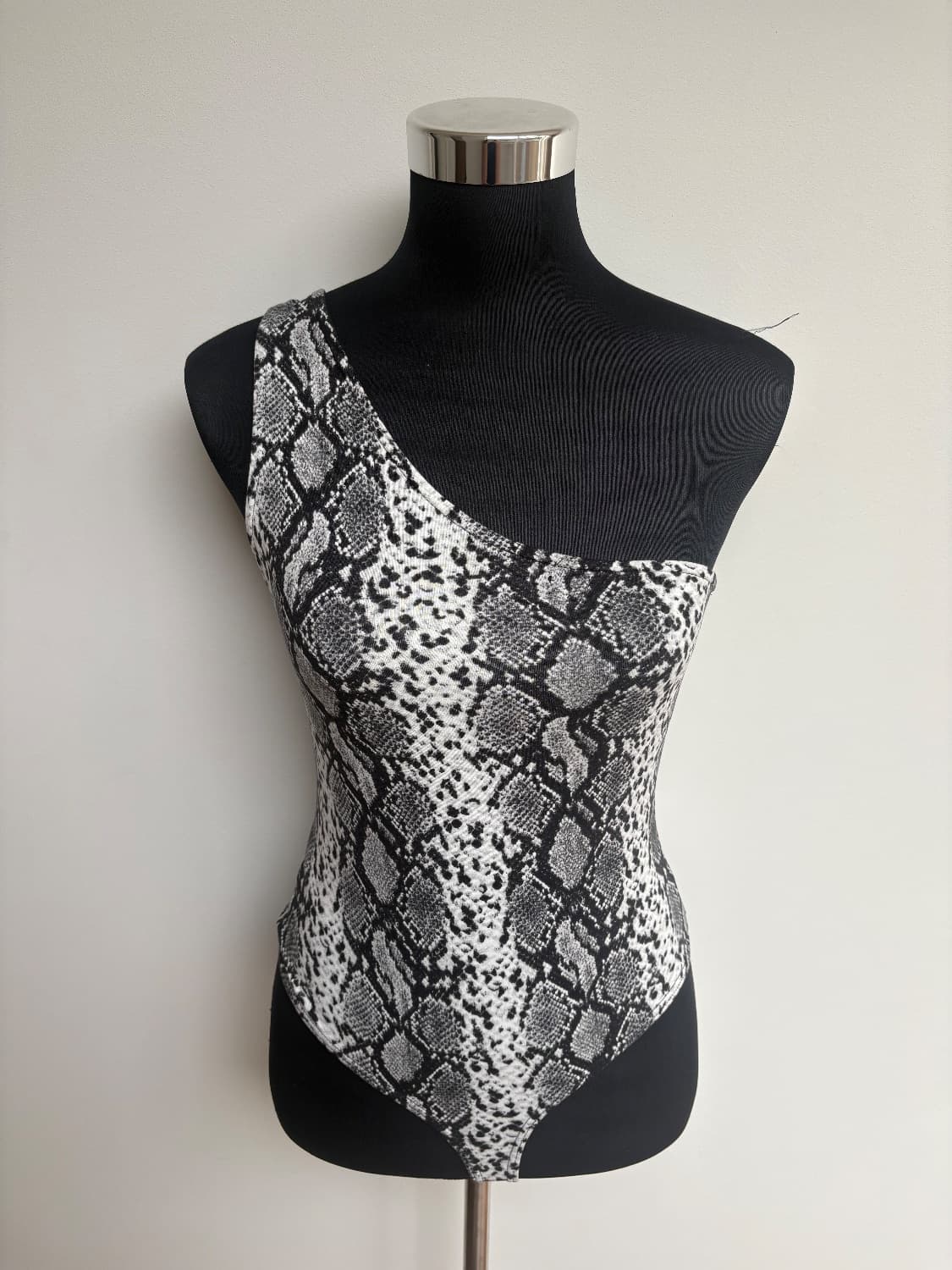 Black and white snake print asymmetrical shoulder body suit made from poly/ spandex the fabric is a 